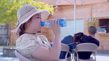 4K升格女生夏季户外休息喝水解渴视频的预览图