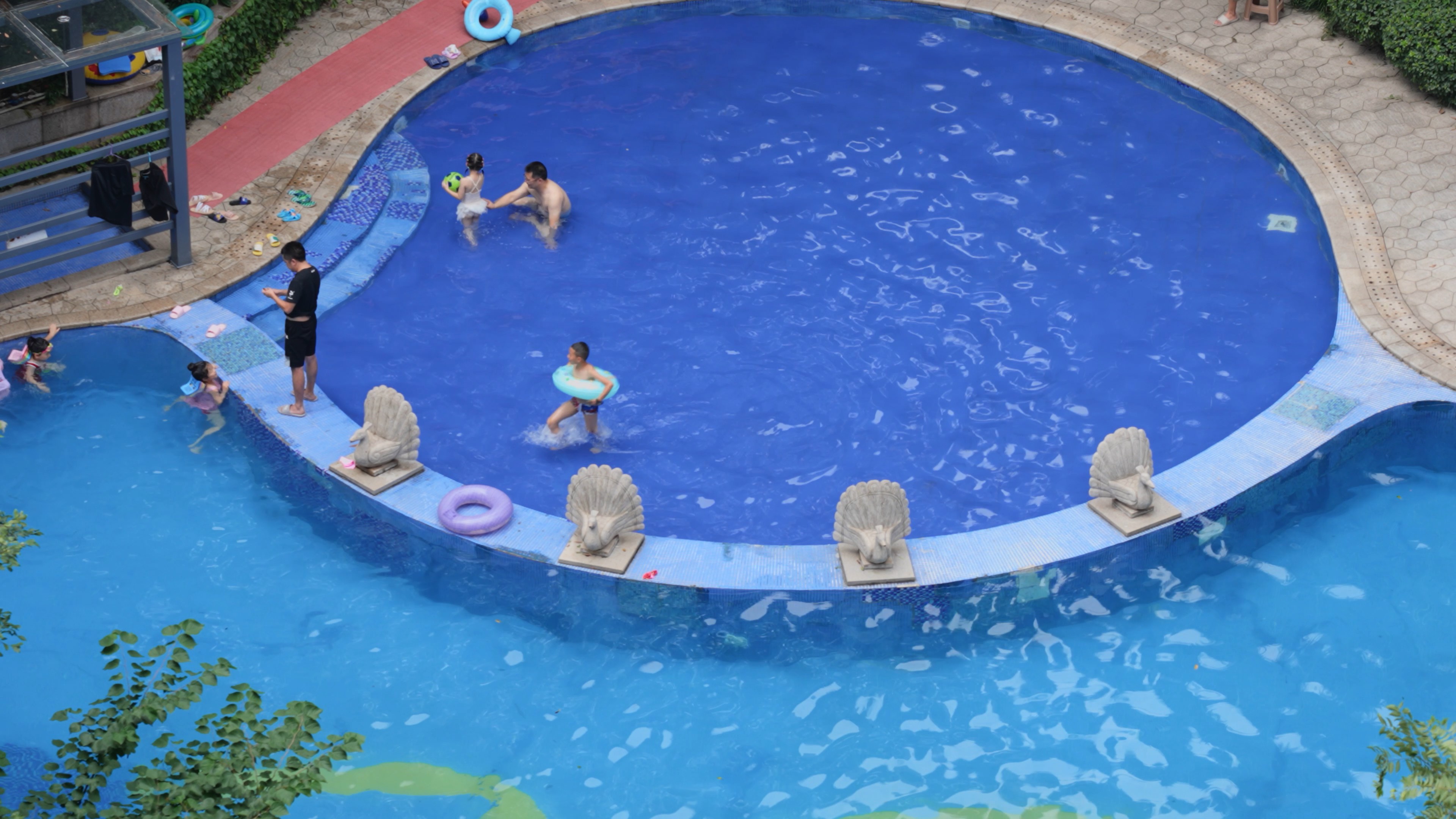 4k水上乐园父母带小孩泳池玩水游泳实拍视频的预览图