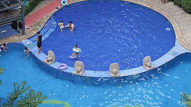 4k水上乐园父母带小孩泳池玩水游泳实拍视频的预览图