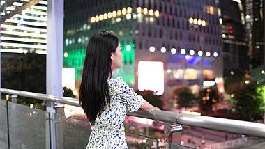 4K夜晚走在天桥上眺望的美女背影空镜视频的预览图