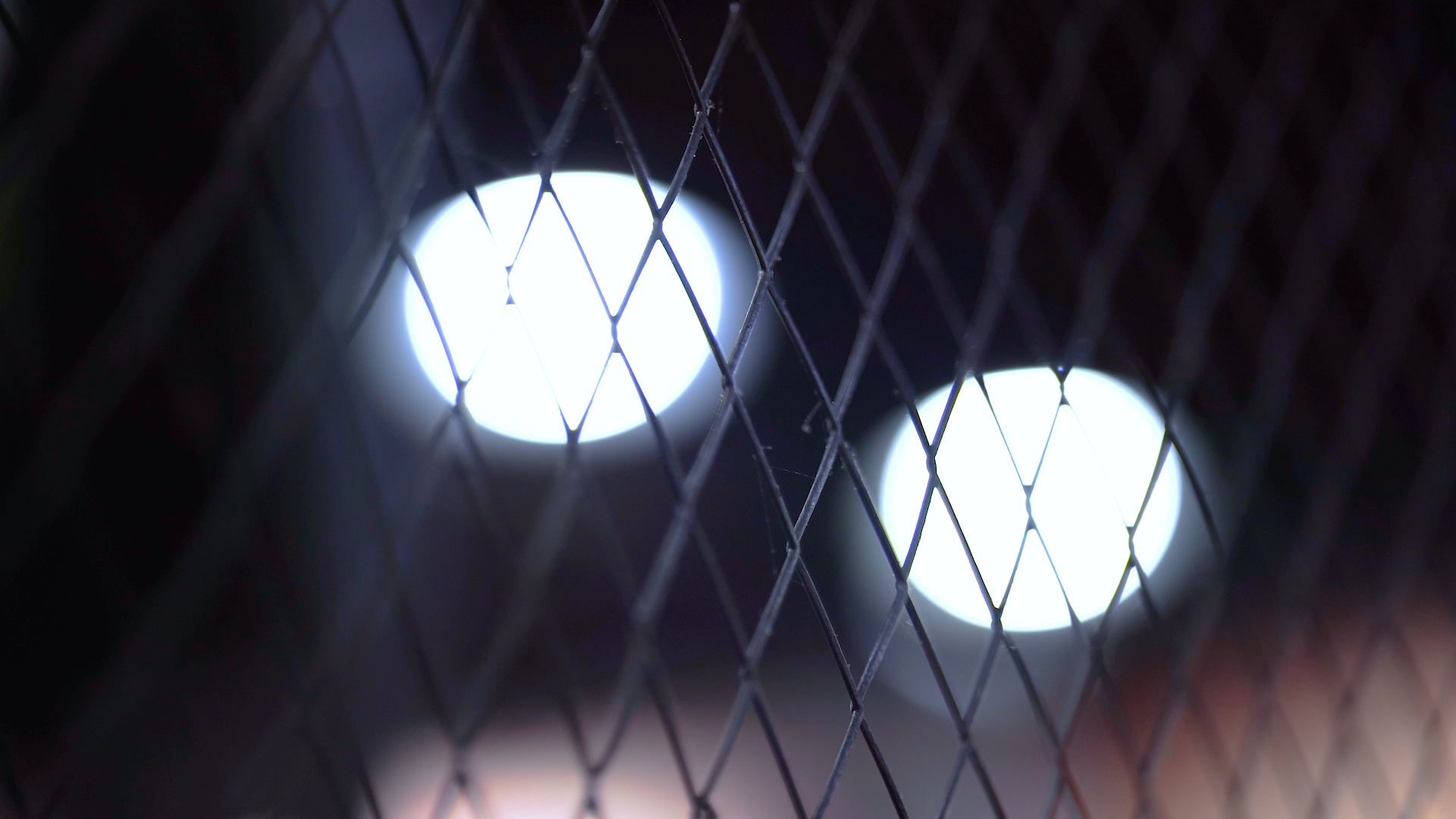 4k实拍夜晚灯光下的铁丝网监狱围栏唯美意境视频的预览图