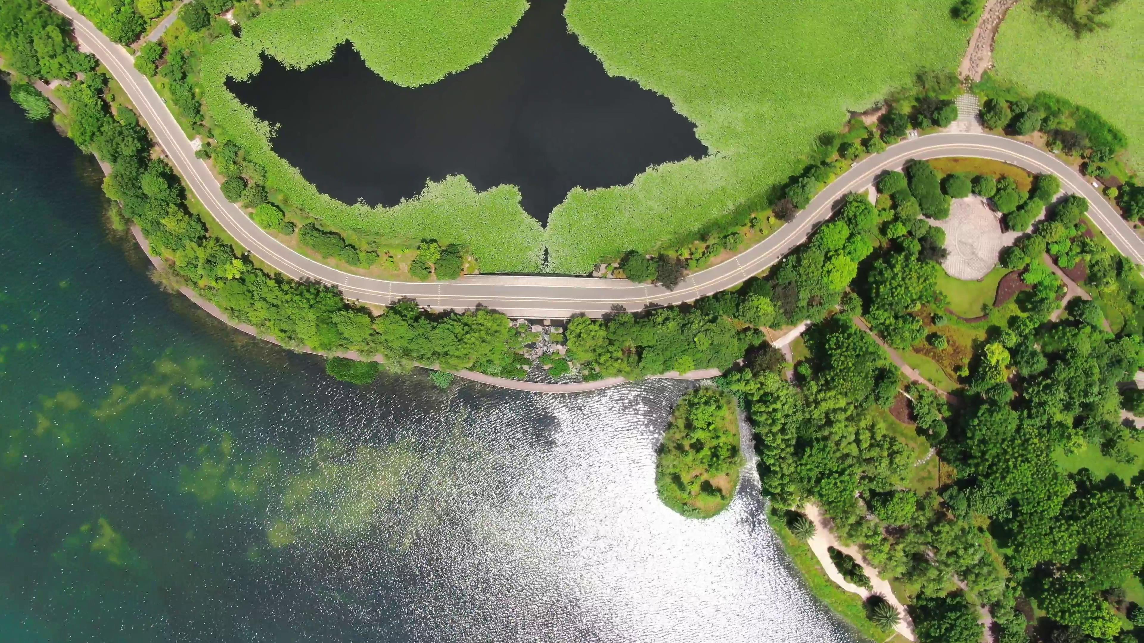 4K俯拍湖面唯美公路自然风景视频视频的预览图