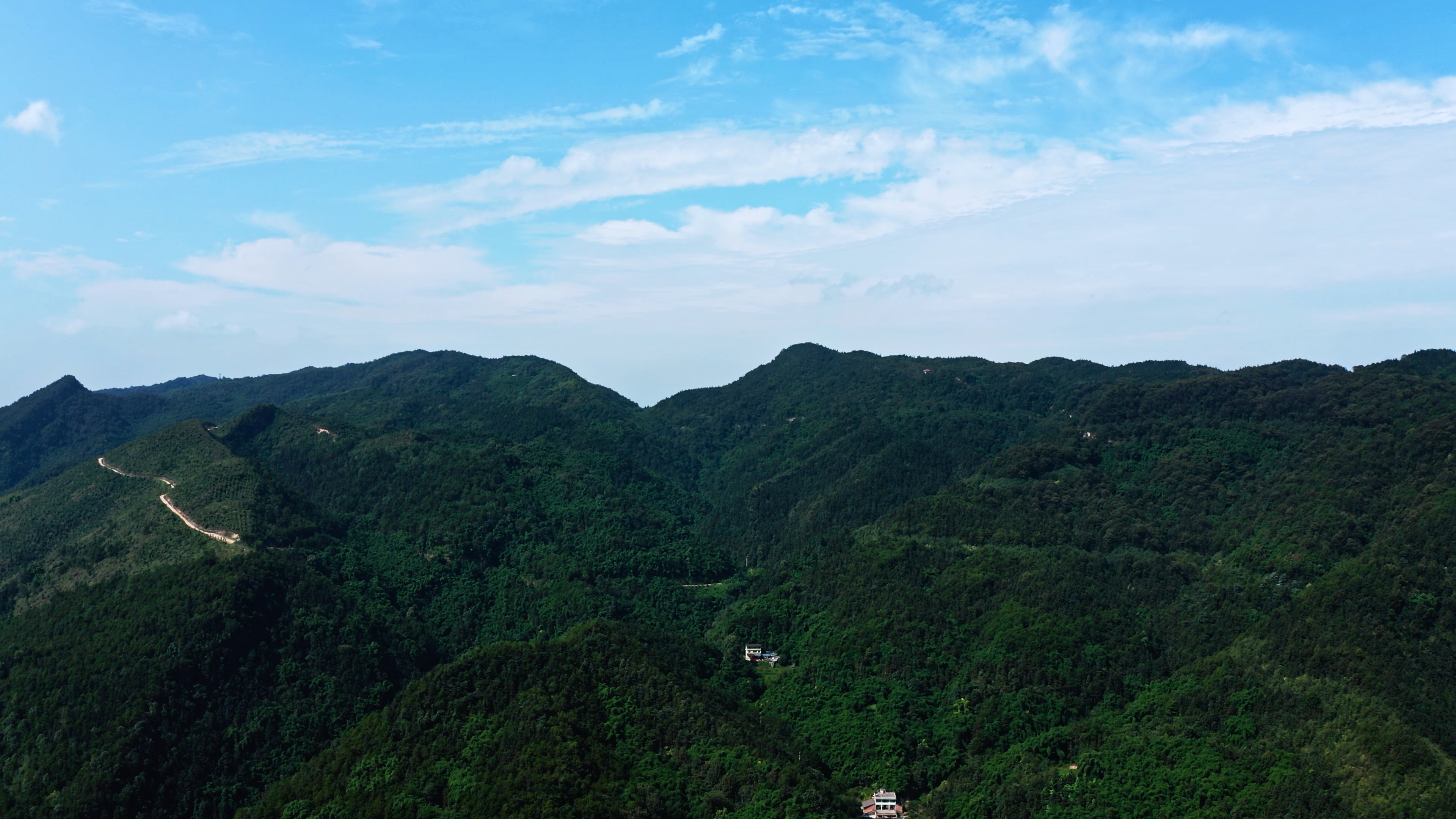 4k航拍蓝天白云下高山绿林壮丽自然风光视频的预览图