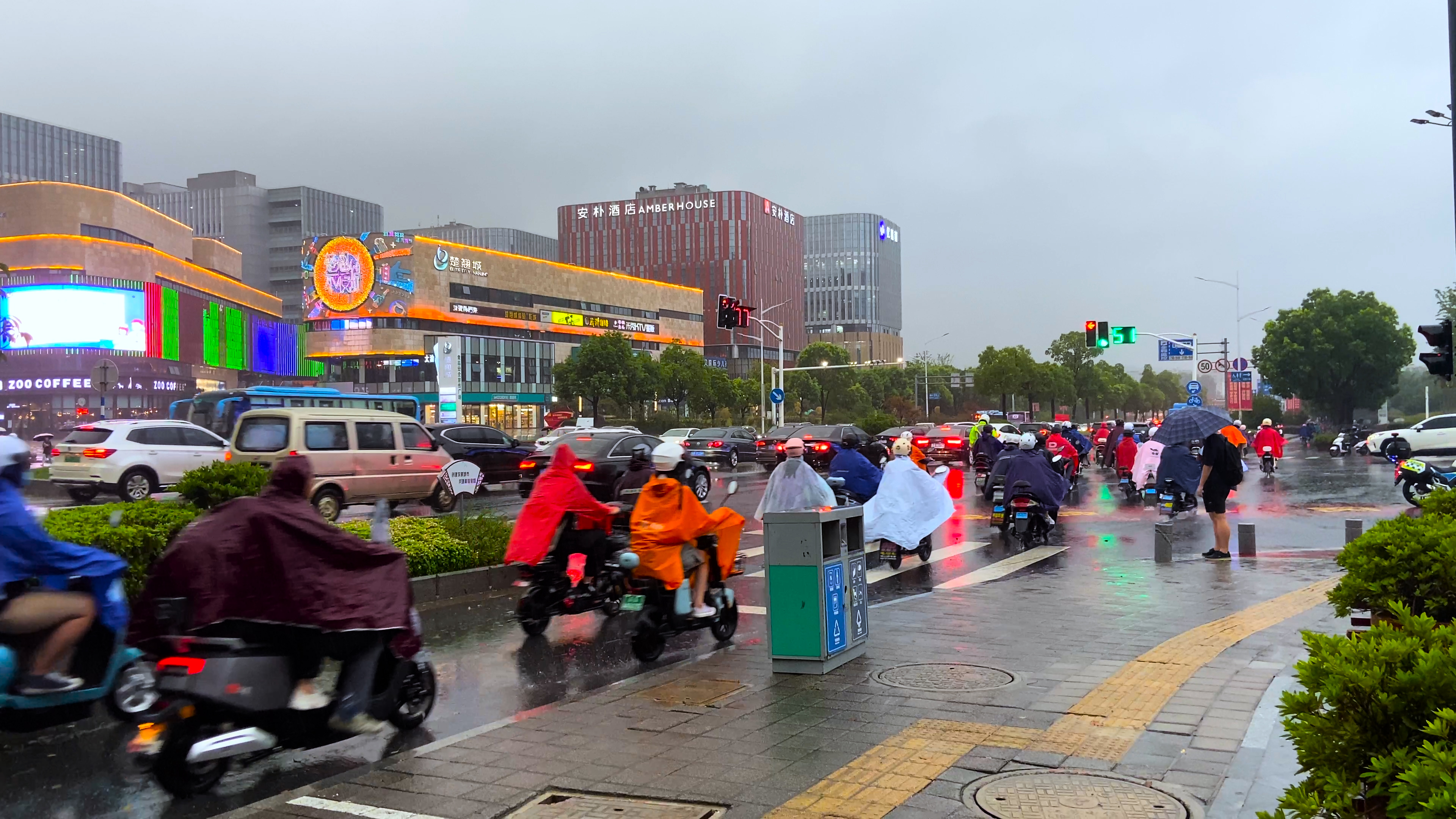 4K实拍下雨天路口行人过马路街景人流民生新闻视频的预览图