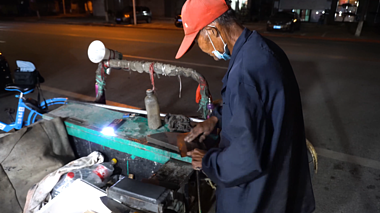4K磨刀匠人老人街头手艺人深夜工作空镜头视频的预览图