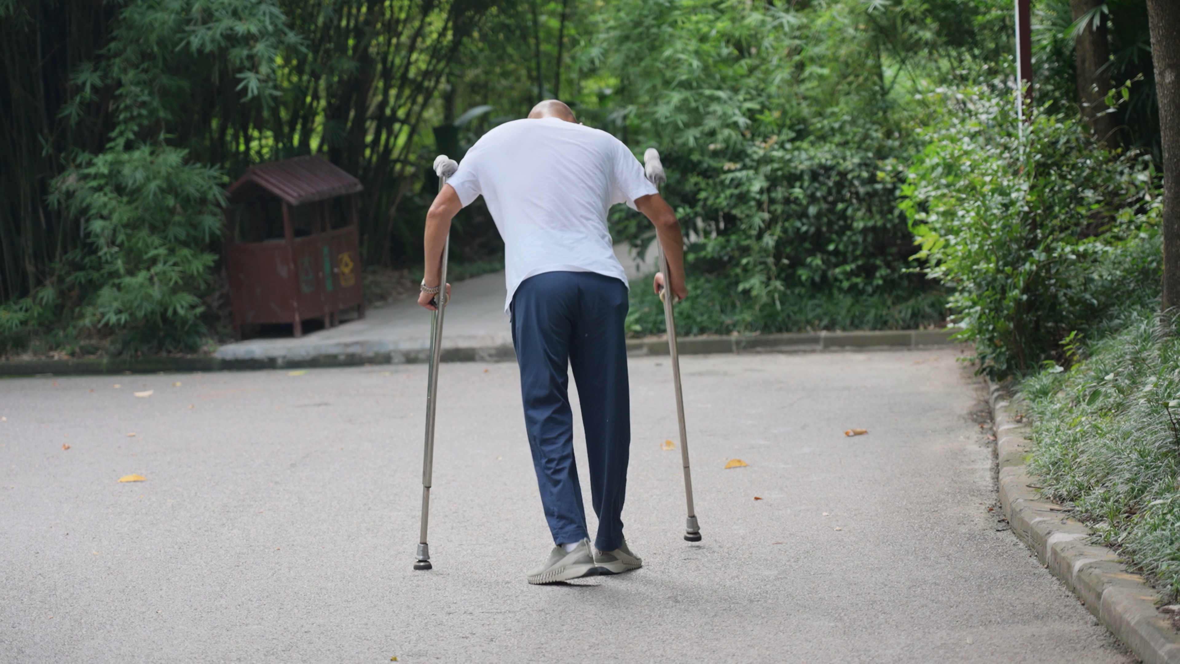 4k拄拐杖艰难行走的男人背影实拍残疾人视频的预览图
