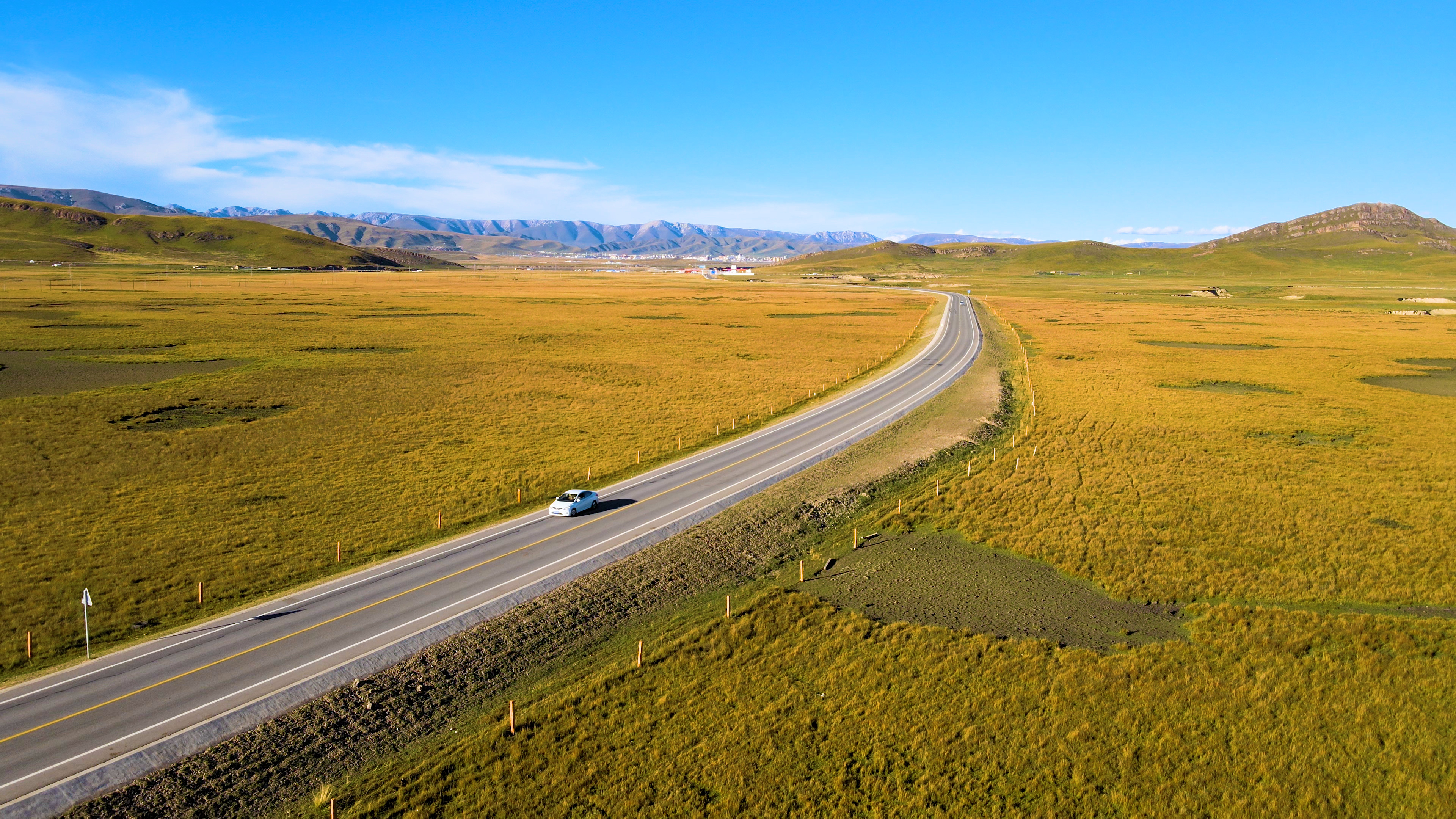4K航拍车辆行驶在草原公路风景视频的预览图