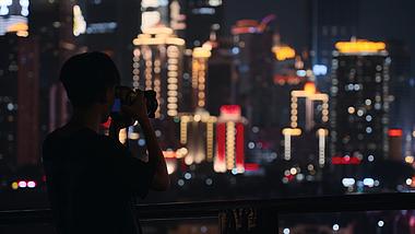 4k城市夜晚灯光下摄影师拍照人物背影视频的预览图
