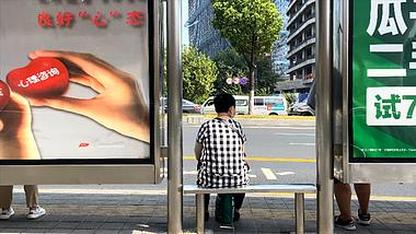 4K实拍老人孤独一人在公交站台等车背影视频的预览图