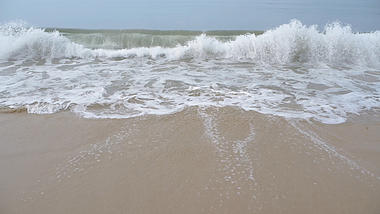 4k白色的浪花拍打着海滩视频的预览图