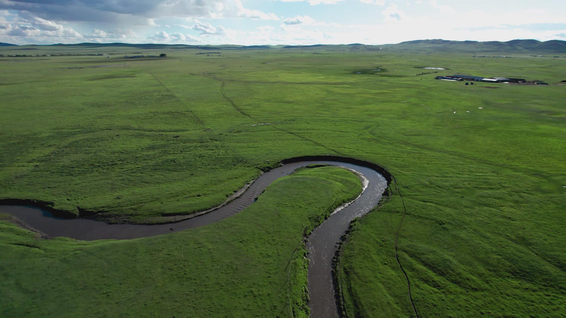 5.4k航拍碧绿的草原上蜿蜒的溪流九曲湾视频的预览图
