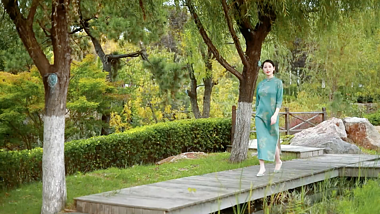 人像旗袍美女绿色全景走过院子视频的预览图