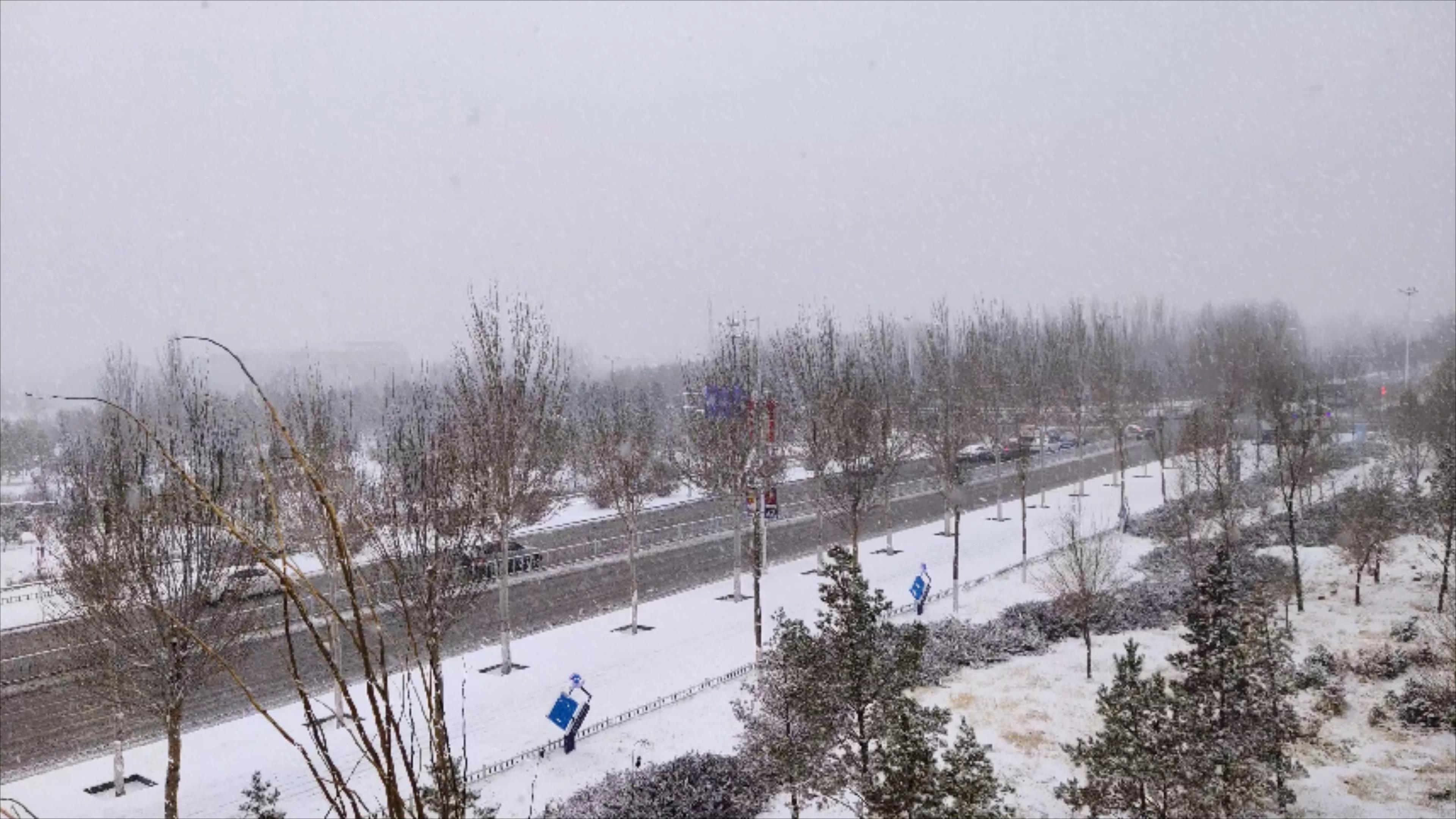 4k拍摄北方城市下雪情景雪中的街道车流视频的预览图