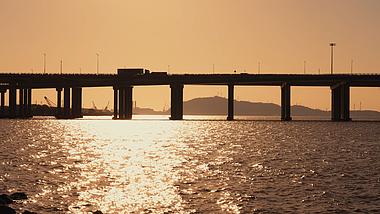4k夕阳下海上大桥车辆行驶唯美空镜视频的预览图