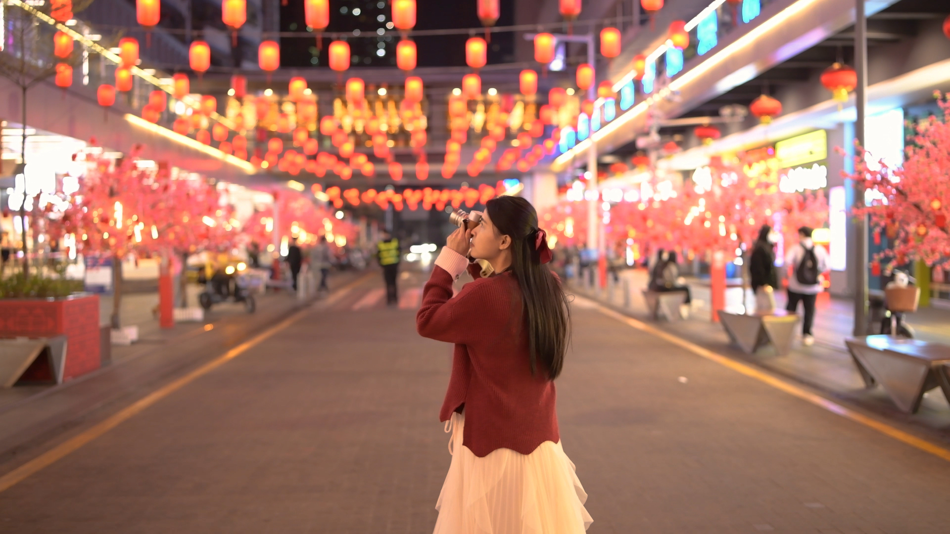 4K新年喜庆春节夜晚街道氛围下拍照的姑娘视频的预览图