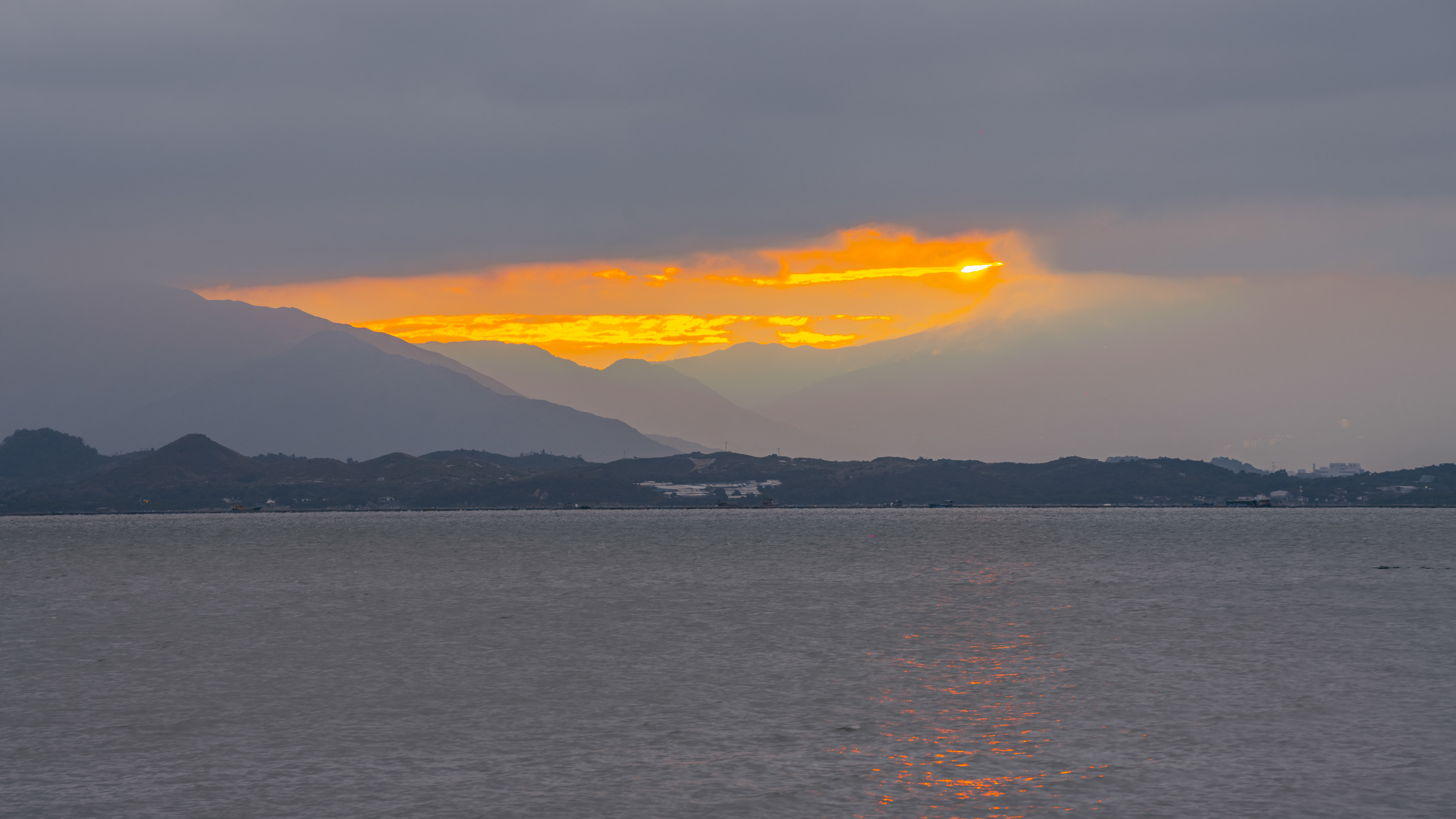 8k延时深圳湾海面日出金光照射在山间风景视频的预览图