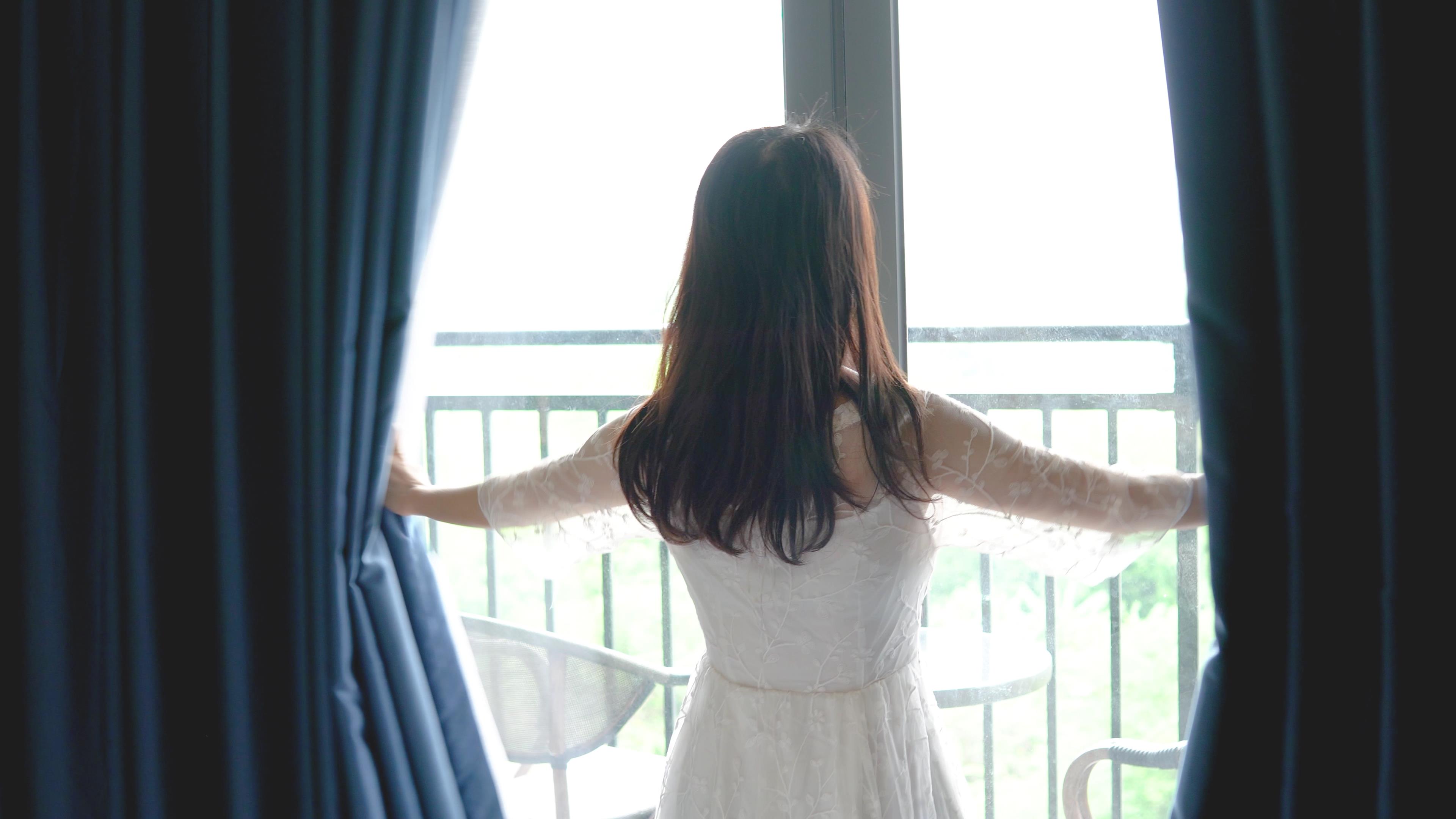 4K实拍女性站在窗前拉开窗帘动作视频的预览图