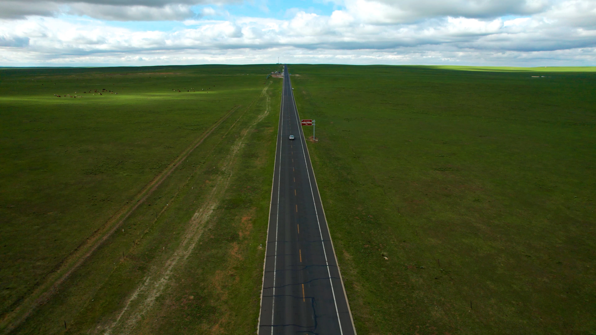 4k航拍汽车行驶在草原的公路上视频的预览图