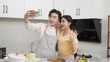 4k在厨房做饭合影的情侣年轻夫妇视频的预览图