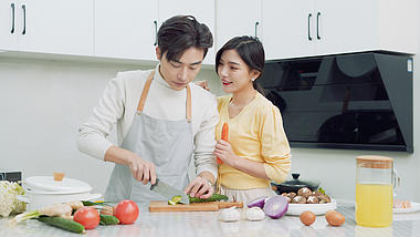 4k情侣年轻夫妇在厨房一起做饭视频的预览图