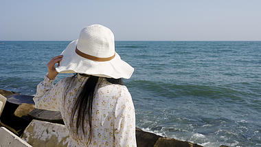 4K海边假日女孩草帽远眺背影视频的预览图