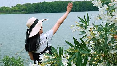夏天女孩在开满白色花的湖边玩耍视频1080视频的预览图