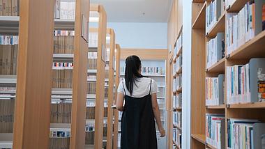 图书馆女孩在书架找书背影实拍视频1080视频的预览图