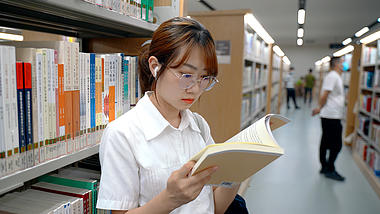 4K实拍女孩图书馆查找书籍阅读视频的预览图
