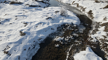 4K航拍北方冬天小溪流水冰河化开空镜头视频的预览图