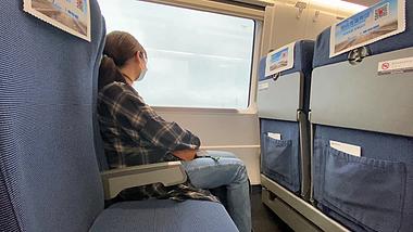 4K实拍女生乘高铁旅途中看向窗外风景视频的预览图