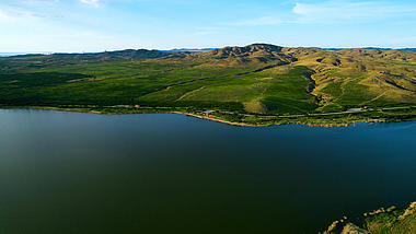 4k航拍蓝天下的美丽草原和湿地湖泊视频的预览图